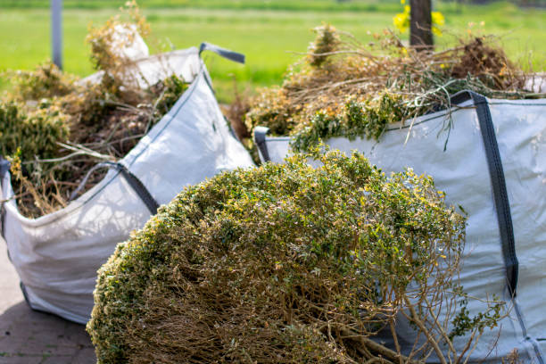 Big white bags filled with organic green garden waste after gardening. Local councils collecting green waste to process it into green energy and compost.